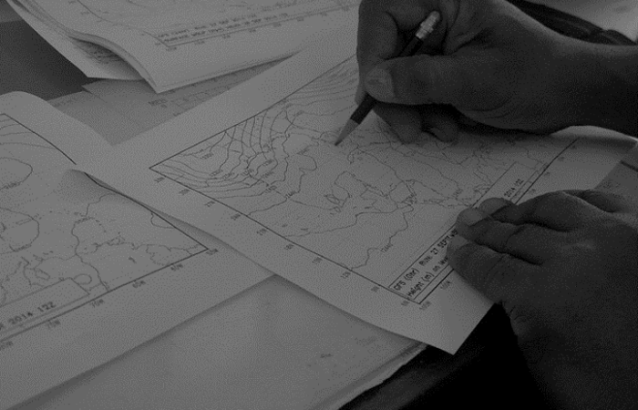 a black and white image of a forecasting chart and someone's hands drawing with a pencil