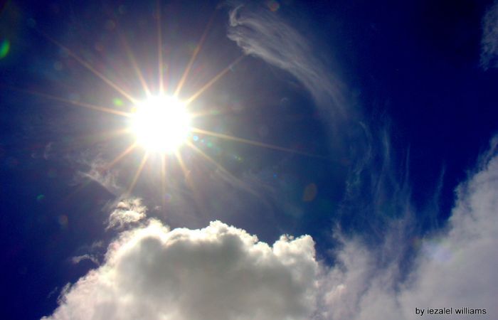a photograph of sun and clouds, looking up 